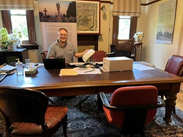 Picture of James sitting in the office at Melbourne General Cemetery.